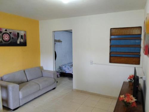 a living room with a couch and a bedroom at Apartamento cercado por natureza e diversão in Maceió