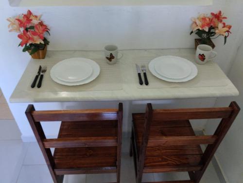 dos platos y dos sillas en una mesa con dos placas andermottermott en Apartamento cercado por natureza e diversão, en Maceió