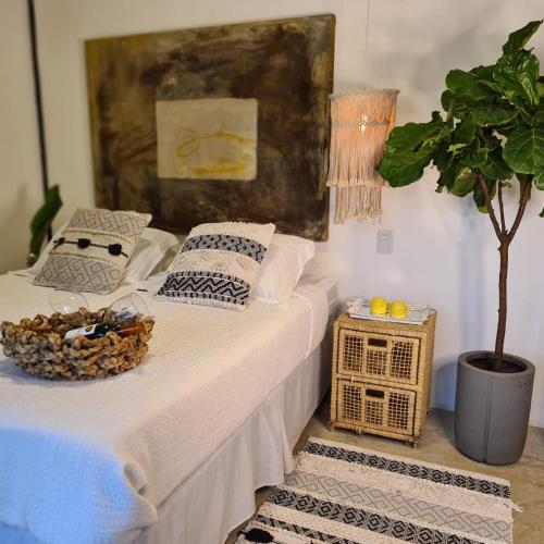 two beds with pillows and a plant in a room at Vila Bambu Ilhabela, Santa Tereza in Ilhabela