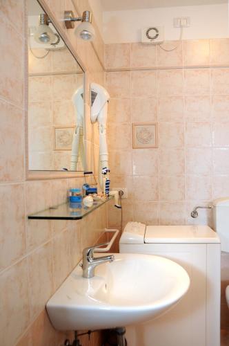 ein Badezimmer mit Waschbecken, Spiegel und Toilette in der Unterkunft Residence Corallo in Caorle