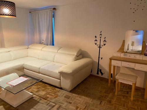 ein Wohnzimmer mit einem weißen Sofa und einem Tisch in der Unterkunft Red appartament in Bagnolo Piemonte