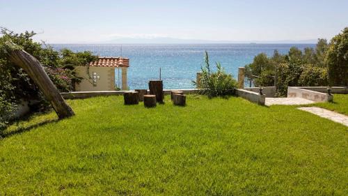 a green yard with a view of the ocean at Beachfront Villa Possidi by Halkidiki Villas in Possidi