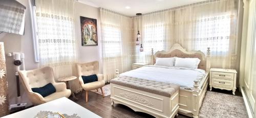 a bedroom with a white bed and two chairs at Mina Akko sea view in Acre