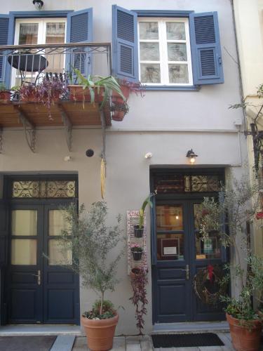 a building with blue doors and windows and potted plants at Amymone and Adiandi in Nafplio