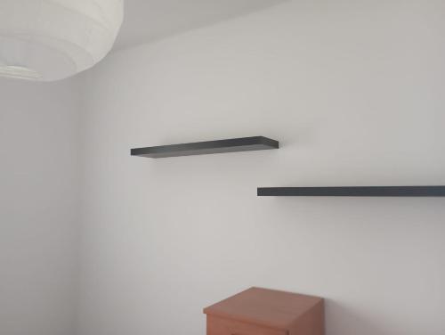 a shelf on a white wall with a box at Niguarda Alfred House in Bresso