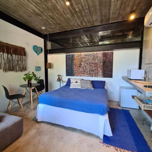 a bedroom with a bed and a table and a couch at Vila Bambu Ilhabela, Santa Tereza in Ilhabela