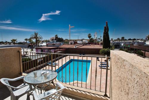 a balcony with a table and a swimming pool at Napiana Apartments in Ayia Napa
