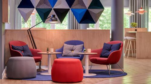 a waiting room with three chairs and a table at Holiday Inn Express Cologne Troisdorf by IHG in Troisdorf