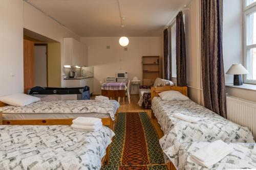 a room with three beds and a kitchen at Püha Vaimu külalistemaja in Tallinn