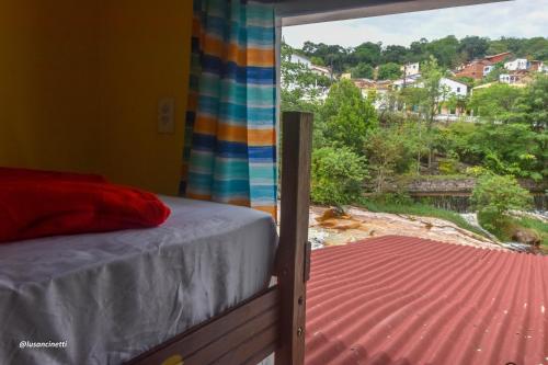 um quarto com uma cama e vista para um telhado em Quinca’s Hostel em Lençóis