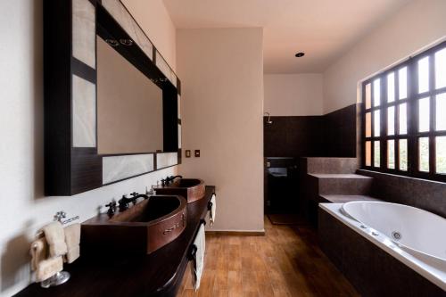 a bathroom with two sinks and a bath tub at Hacienda Maria Eugenio in Guanajuato
