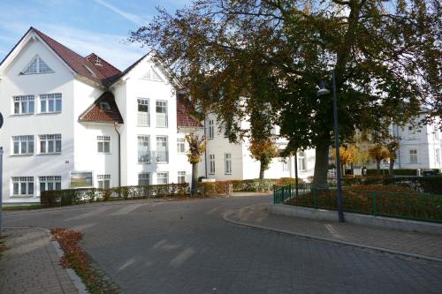 una calle frente a dos casas blancas en Schloss Hohenzollern - Wohnung 03, en Ahlbeck