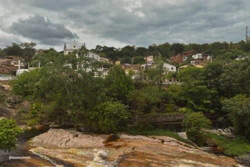 a town on a hill next to a river at Quinca’s Hostel in Lençóis