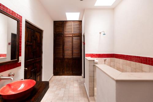 a bathroom with a red toilet and a tub and a sink at Hacienda Maria Eugenio in Guanajuato