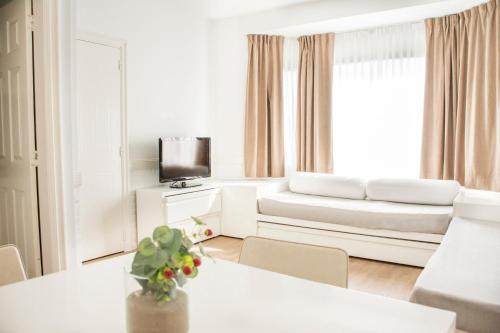 a white living room with a couch and a table at Pinamar Beach Resort in Pinamar
