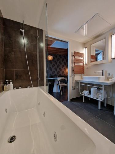 a large bathroom with a tub and a sink at Domaine de l'Epau Eco-Resort - Eco-Lodges in Yvré-lʼÉvêque