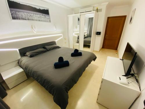 um quarto com uma cama com duas almofadas azuis em Fantastic Anfi Tauro Duplex with ocean view em Las Palmas de Gran Canaria