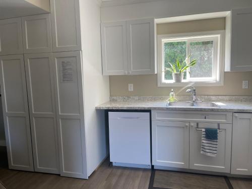 a kitchen with white cabinets and a sink and a window at Villa in the Vines in Niagara on the Lake