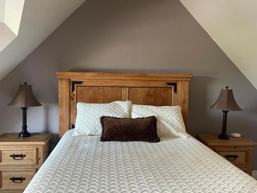 1 dormitorio con 1 cama con cabecero de madera y 2 lámparas en Villa in the Vines, en Niagara on the Lake