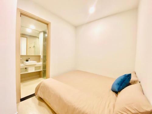 a white bedroom with a bed and a mirror at Căn hộ The Sóng An Gia - Vũng Tàu Apartment in Vung Tau