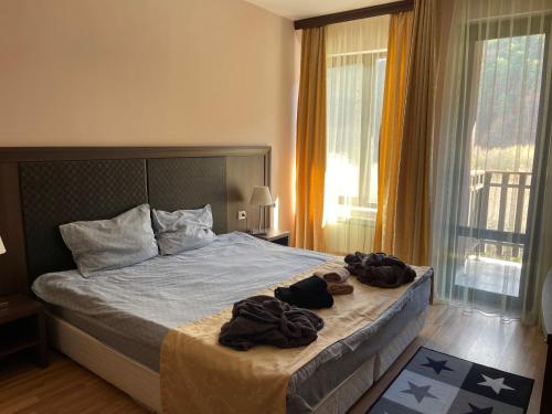 1 dormitorio con 1 cama con toallas en Мия 3 Спа хотел Свети Спас, en Velingrad