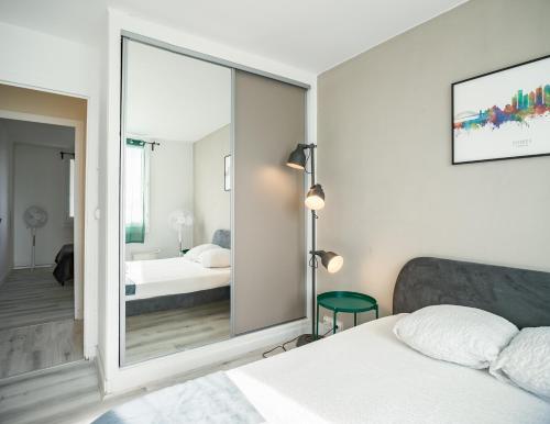 une chambre avec un grand miroir et un lit dans l'établissement Le Gatsby - 3 chambres - Centre-Ville, à Troyes