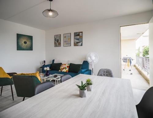 un salon avec une table et un canapé dans l'établissement Le Gatsby - 3 chambres - Centre-Ville, à Troyes