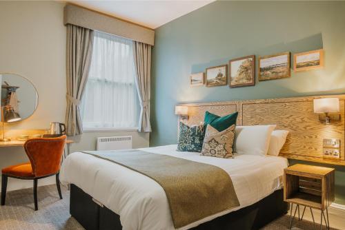 1 dormitorio con cama, escritorio y ventana en Grouse & Claret, Matlock by Marston's Inns, en Matlock
