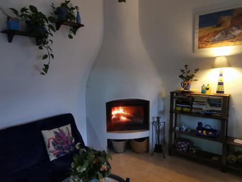 a living room with a fireplace in the corner at Caseta de pescadors a les cales de Colera, 2ª linea de mar in Colera