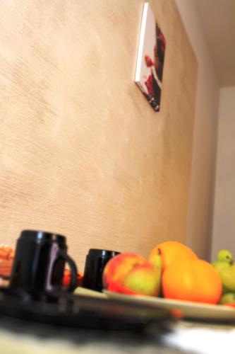a plate of apples and oranges on a table at B&B Tra Monti e Mare in Ogliastro Cilento