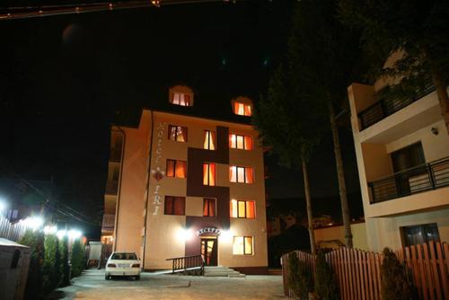 a tall building with lit up windows at night at Hotel Iri in Buşteni