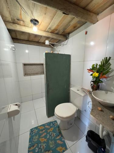 uma casa de banho com um WC branco e um lavatório. em Pousada Maré Alta em Boipeba na Ilha de Boipeba