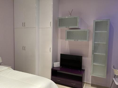 een slaapkamer met een bed en een flatscreen-tv bij Piraeus Cozy in Piraeus