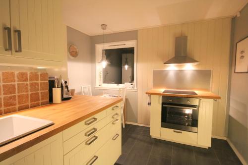 uma cozinha com armários brancos e um forno com placa de fogão em Herøya Porsgrunn Apartment em Porsgrunn