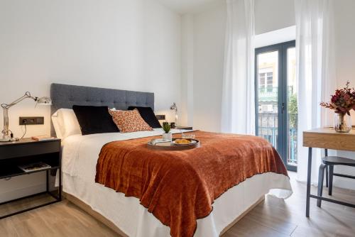 ein weißes Schlafzimmer mit einem großen Bett und einem Fenster in der Unterkunft Avanti Buganvilla, la Sevilla auténtica in Sevilla
