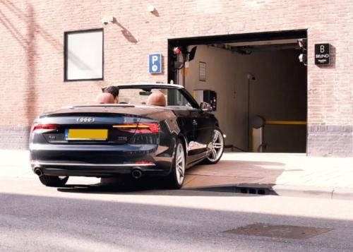 a black car parked in front of a garage at Room Mate Bruno, Rotterdam in Rotterdam