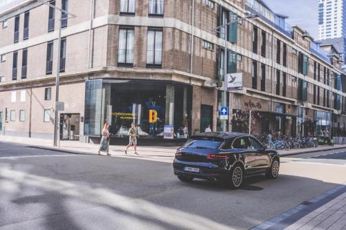 a black car is driving down a city street at Room Mate Bruno, Rotterdam in Rotterdam