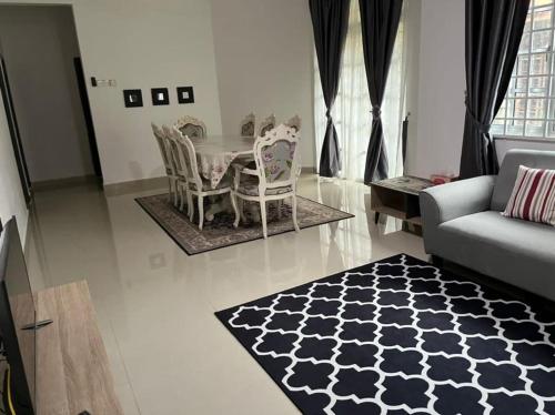 a living room with a table and chairs and a couch at warisan gp homestay in Kuala Terengganu