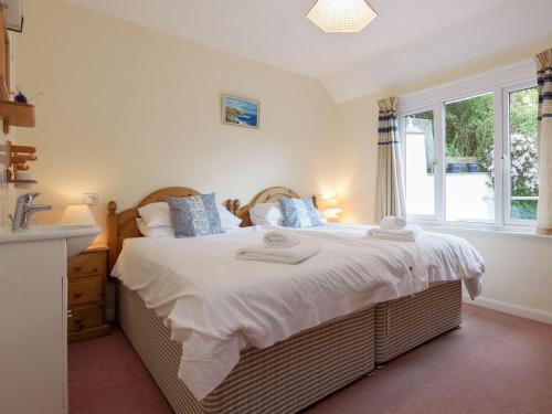 a bedroom with a large bed and a window at St Elmo Lodge in Salcombe