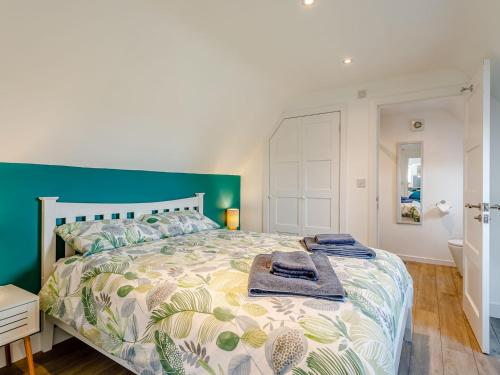 a bedroom with a large bed with a green headboard at Home Farm Lodge in Baston