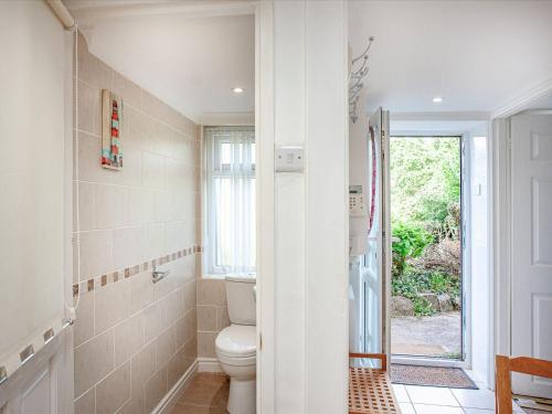 a bathroom with a toilet and a window at Westerlands Apartment in Torquay