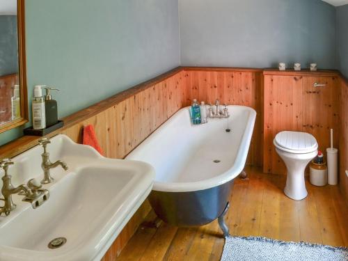 y baño con bañera, lavabo y aseo. en Fox Cottage en Beverley