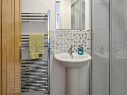 a bathroom with a sink and a mirror and a shower at Park Crescent in Creetown