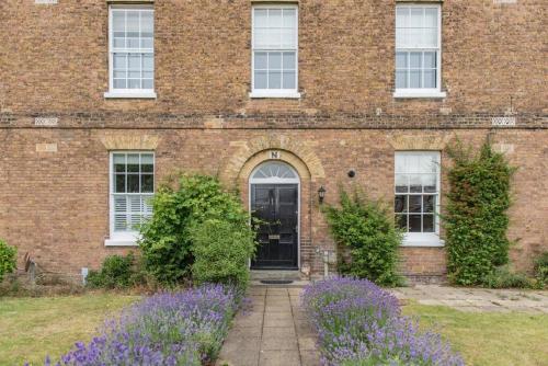 a brick building with purple flowers in front of it at Admiralty House in Deal