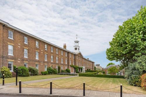 a large brick building with a clock tower at Admiralty House in Deal