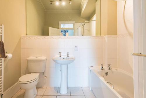 a bathroom with a toilet and a sink and a tub at Admiralty House in Deal