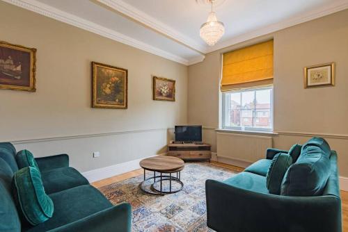 a living room with two blue couches and a television at Admiralty House in Deal
