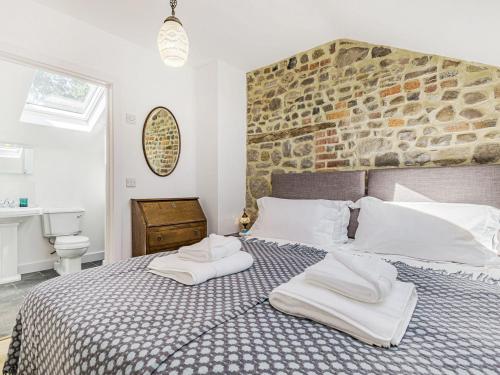 um quarto com uma cama grande e toalhas em The Stables - Uk40093 em Bryngwyn