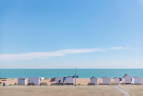 a row of beach huts next to the ocean at Admiralty House in Deal