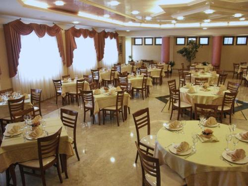 a dining room with tables and chairs and a room filled with tables and chairsktop at Albergo Casa Del Pellegrino in Monte SantʼAngelo
